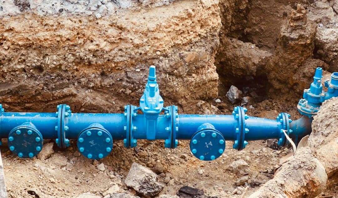 Cano azul de abastecimento de água sobre solo exposto