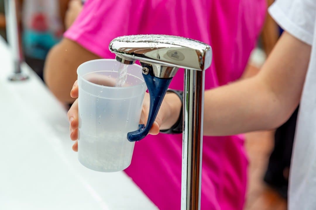 Pessoa enchendo copo com água potável limpa da torneira