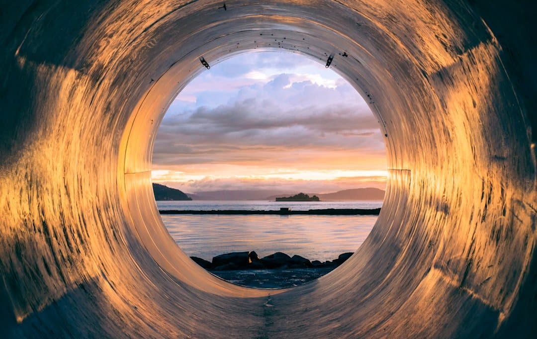 Corpo d'água visto através de túnel de infraestrutura hídrica